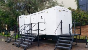 White luxury porta potty trailer in a park