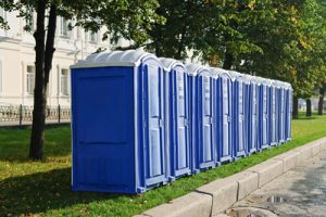 row of porta potties next to a curb